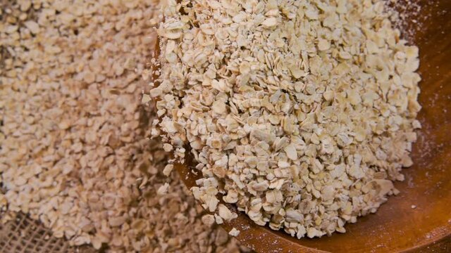 Slow-motion of wheat flakes dropping on the burlap cloth