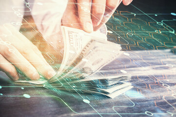 Double exposure of technology drawing hologram and us dollars bills and man hands. Data concept