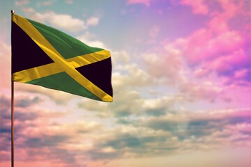 Fluttering Jamaica flag mockup with the space for your content on colorful cloudy sky background.