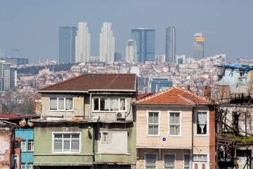 Fototapeta premium Front view, old houses standing in front of luxury and modern building background. Wealth and poverty, distorted urbanization concept.