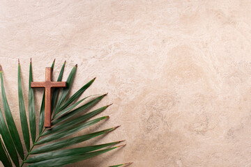 Palm Sunday concept. Wooden cross over palm leaves. Reminder of Jesus sacrifice and Christ resurrection. Easter passover. Eucharist concept. Christianity symbol and faith - 423516719