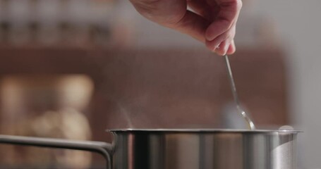 Slow motion man hand stir fettuccine pasta in saucepan with boiling water closeup - Powered by Adobe