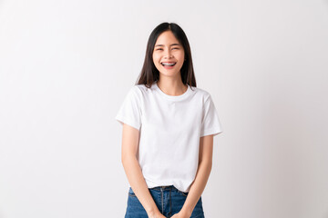 Studio shot of cheerful beautiful Asian woman in white t-shirt and stand smiling with braces on white background.