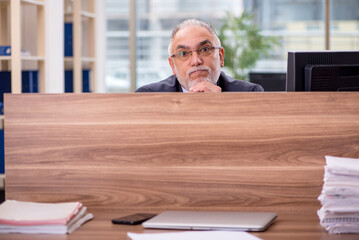 Fototapeta premium Old male employee sitting in the office