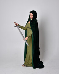 full length portrait of red haired girl wearing celtic, green medieval gown with fantasy velvet...