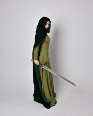 full length portrait of red haired girl wearing celtic, green medieval gown with fantasy velvet...