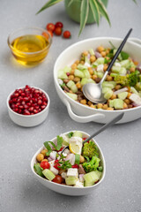 fresh green salad served in a white bowl with beans, legumes, and pomegranate seeds