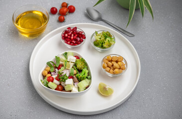 fresh green salad served in a white bowl with beans, legumes, and pomegranate seeds