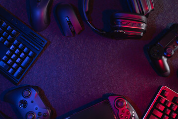 gamer work space concept, top view a gaming gear, mouse, keyboard, joystick, headset with rgb color...