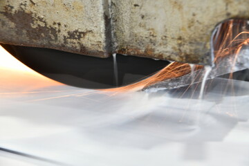 Fototapeta na wymiar Metal processing by grinding on a surface grinding machine with sparks and water cooling.
