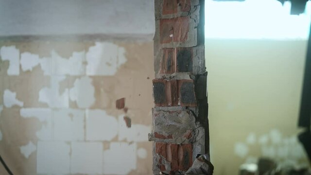 Side view. Workers break the wall with heavy hammers.