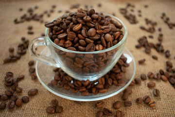 A clear glass cup full of coffee beans. Close-up.