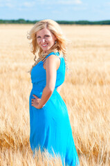 Happy womanin blue dress  in golden wheat