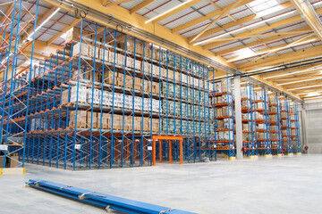 Interior view of a warehouse with racks, pallets, goods, forklifts