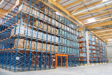 Interior view of a warehouse with racks, pallets, goods, forklifts