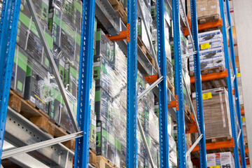 Interior view of a warehouse with racks, pallets, goods, forklifts