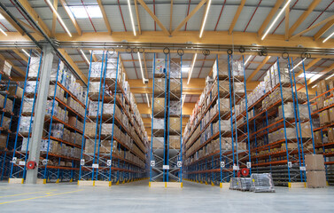 Interior view of a warehouse with racks, pallets, goods, forklifts