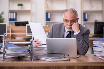 Naklejka premium Old male employee unhappy with excessive work in the office
