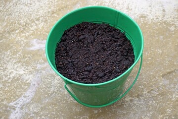 Wet soil inside the green flower pot. 