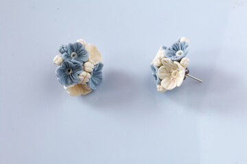 Handmade jewelry. Earrings made of polymer clay. Lies on a white surface.