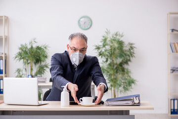 Old male boss employee working during pandemic