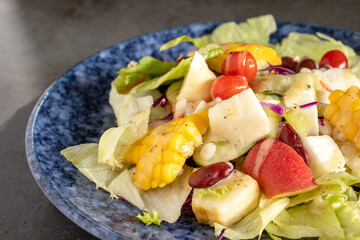 Fresh vegetable salad and fruit salad on the black stone table