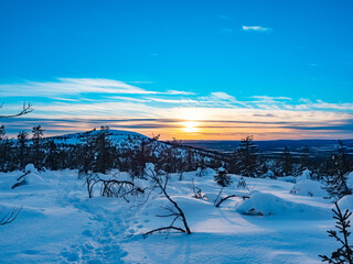 Hiking path in snowy mountains during sunset in Lapland, Finland
