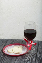 A glass of dry red wine and unleavened bread on a plate. Celebration of the Lord's Supper.
