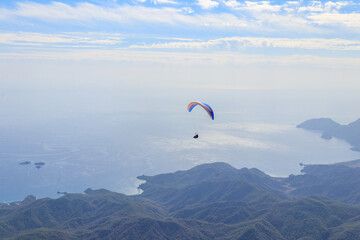 Paragliders flying from a top of Tahtali mountain near Kemer, Antalya Province in Turkey. Concept of active lifestyle and extreme sport adventure
