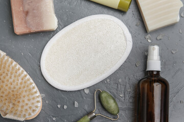 Natural organic skin care product. Home spa and self care products top view. Facial serums, creams, jade roller and various toiletries on textured grey background.
