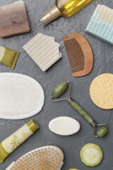 Natural organic skin care product. Home spa and self care products top view. Facial serums, creams, jade roller and various toiletries on textured grey background.