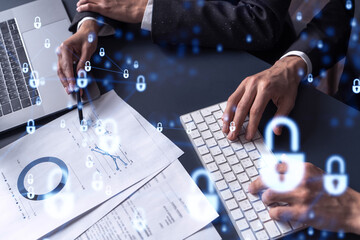 Two businesspeople man and woman working on the project to protect cyber security of international company. Padlock Hologram icons over the table with documents. Formal wear. Workspace.