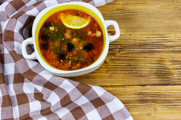 Traditional russian hodgepodge soup on a wooden table. Top view