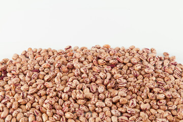 Pinto beans, a legume native to the American continent; photo on white background.