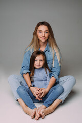 Attractive mother with daughter sitting on the floor.