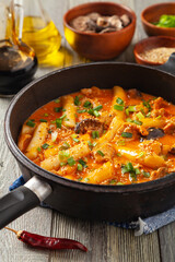 Traditional Korean Tteokbokki rice noodles with chicken, vegetables and shitake mushrooms. Prepared in a pan.