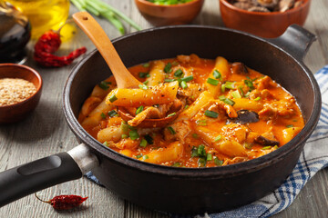 Traditional Korean Tteokbokki rice noodles with chicken, vegetables and shitake mushrooms. Prepared in a pan.