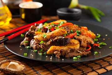 Traditional Korean Tteokbokki rice noodles with beef, vegetables and shitake mushrooms. Prepared in a wok.