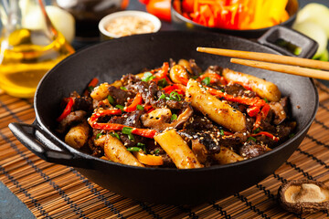 Traditional Korean Tteokbokki rice noodles with beef, vegetables and shitake mushrooms. Prepared in a wok.