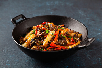 Traditional Korean Tteokbokki rice noodles with beef, vegetables and shitake mushrooms. Prepared in a wok.