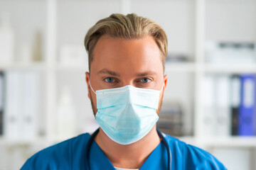 Fototapeta na wymiar Professional medical doctor in hospital office, Portrait of young and confident physician in protective mask.