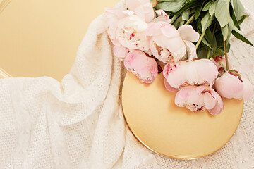Styled composition with pink tulips on gold background. Flat lay floral frame and white textile. Border top view.