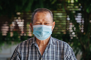 close-up portrait of happy asian senior man wear a mask looking at camera. Old thai man