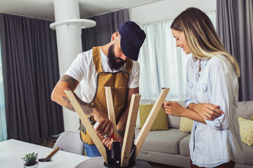 Wife helping husband to repair broken chair at home