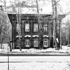 Old wooden houses under the snow. Russia. Siberia. Winter. The city of Tomsk 2021. Multifamily residential wooden houses of the 19th century.