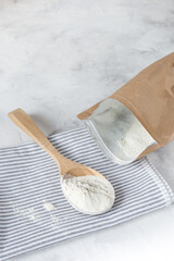 Crumbly xanthan gum in a wooden spoon.