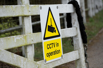 Generic CCTV Warning Sign seen attached to a garden fence at a rural location. The sign helps deter would-be criminals they are being recorded.