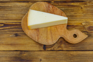 Piece of cheese on a wooden table. Top view