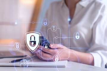 A woman programmer is browsing the Internet in smart phone to protect a cyber security from hacker attacks and save clients confidential data. Padlock Hologram icons over the typing hands. Formal wear