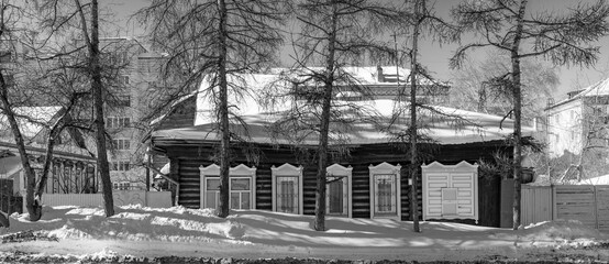 Old wooden houses under the snow. Russia. Siberia. Winter. The city of Tomsk 2021. Multifamily residential wooden houses of the 19th century.